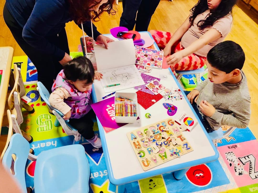picture of kids in a daycare playing together with a childcare provider